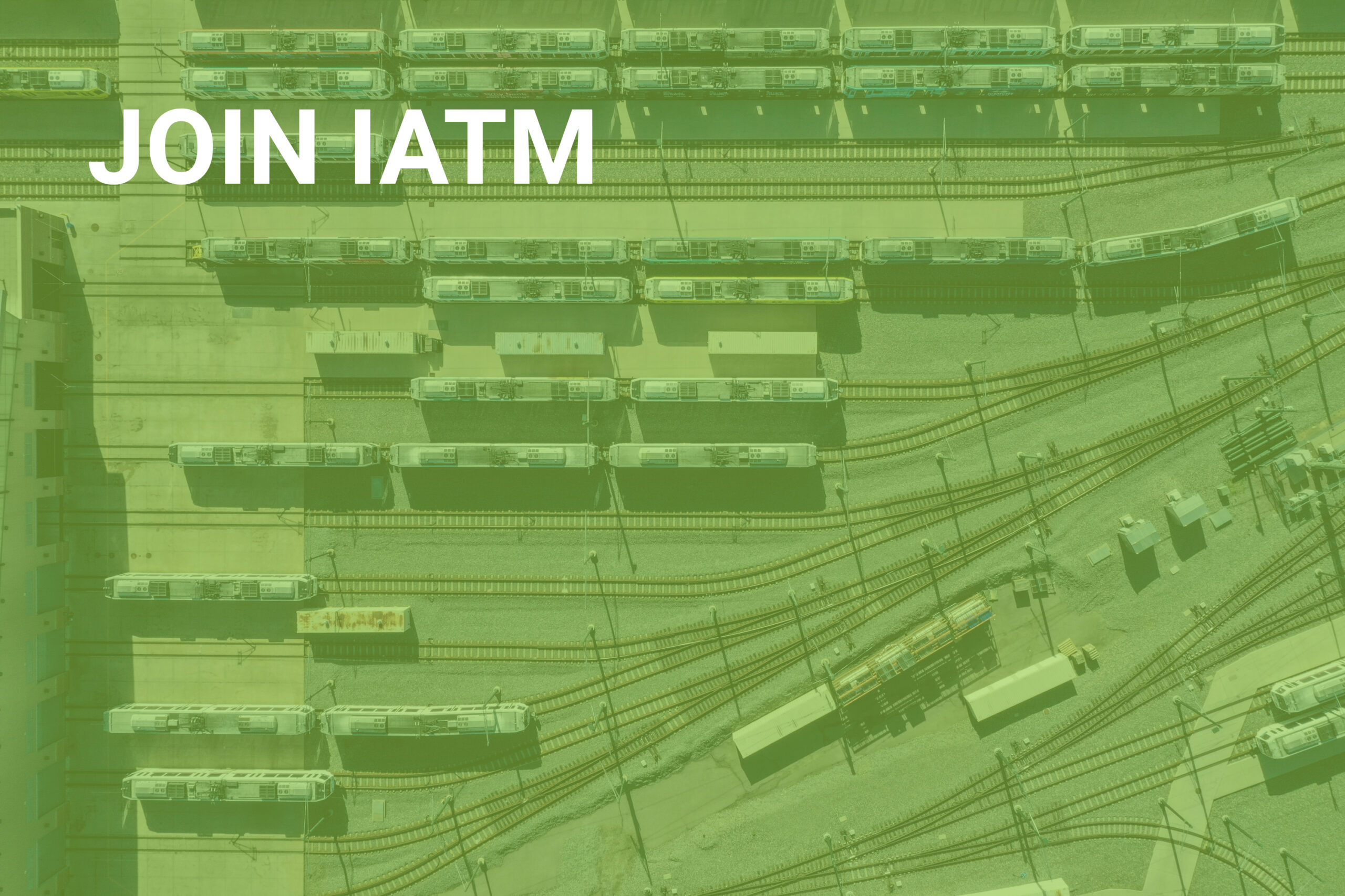 Aerial view of train tracks at a railway yard covered by a slightly transparent green screen text in top left hand corner: Join IATM