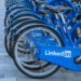 A row of blue bicycles with the label "LinkedIn" visible on the protection case of the bicycle chain.